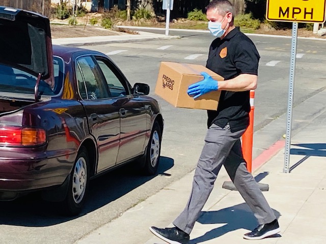 SJ Van Horn delivering a food box to a resident's vehicle during an Esmeralda Soria community food drive